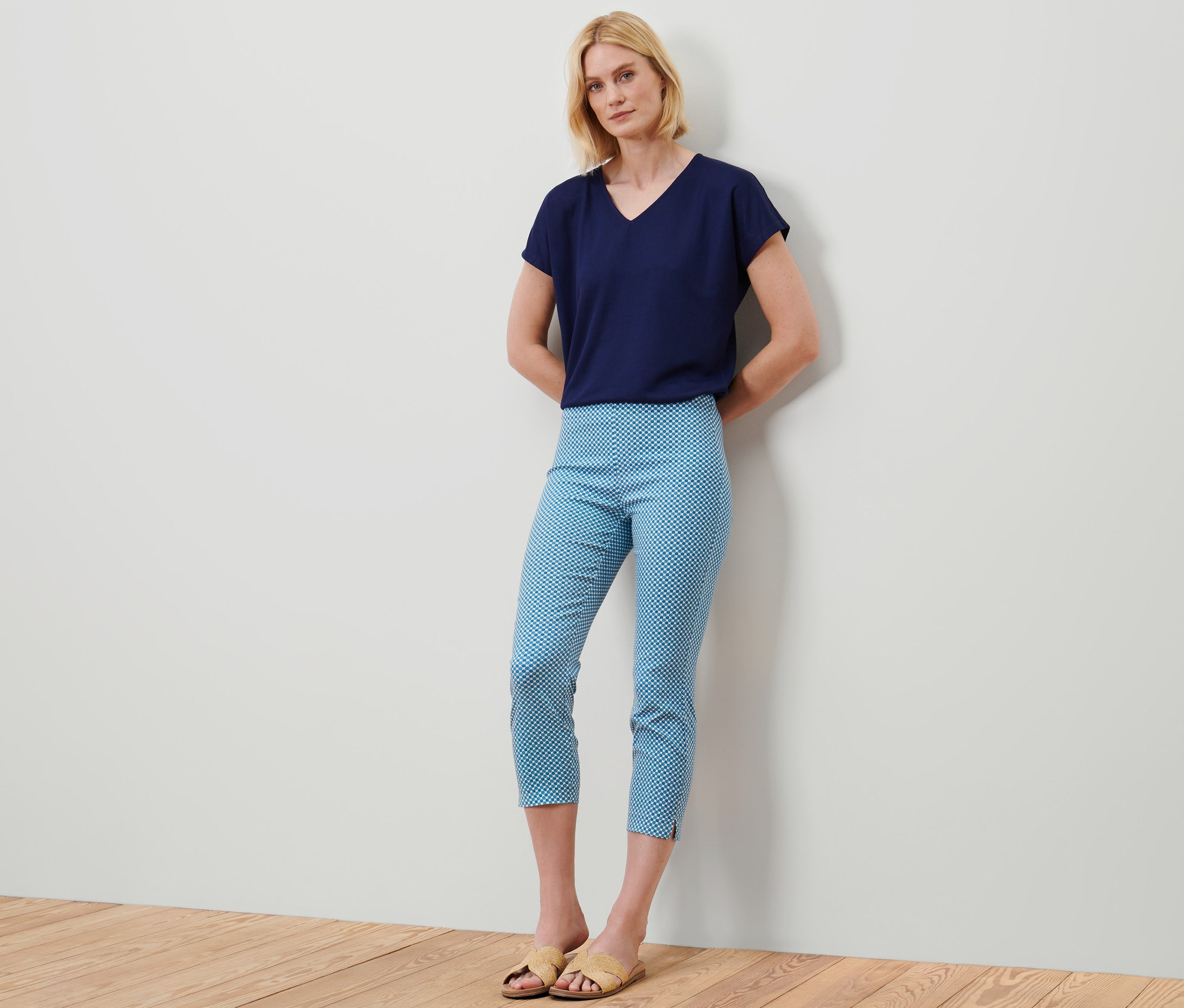 Une femme debout porte un t-shirt bleu et un pantalon stretch 7/8 avec un imprimé intégral.