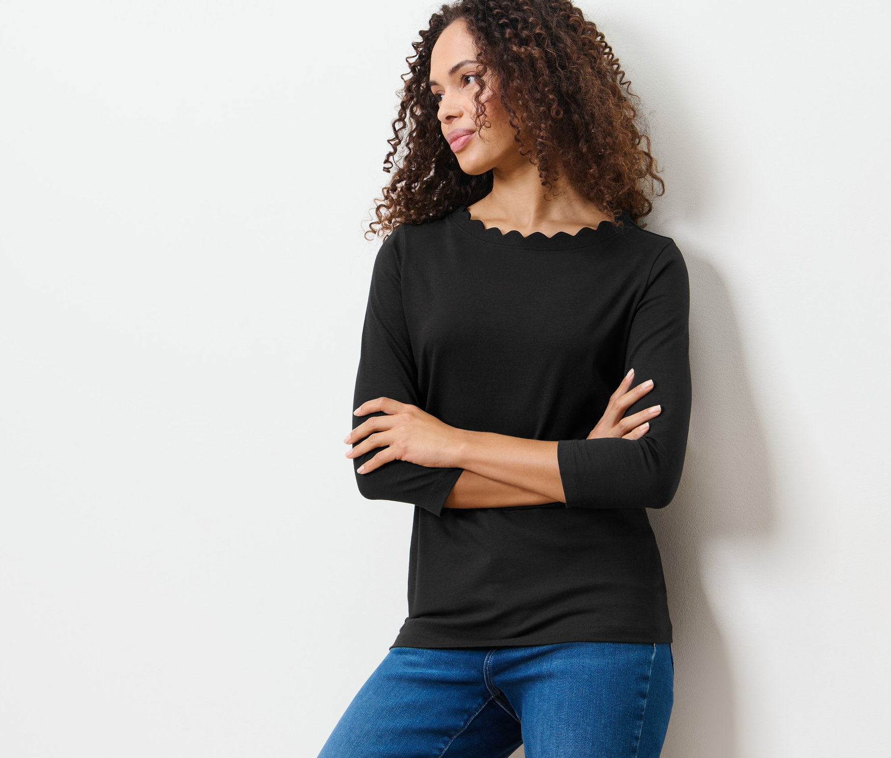 Femme posant dans un t-shirt noir à manches 3/4.