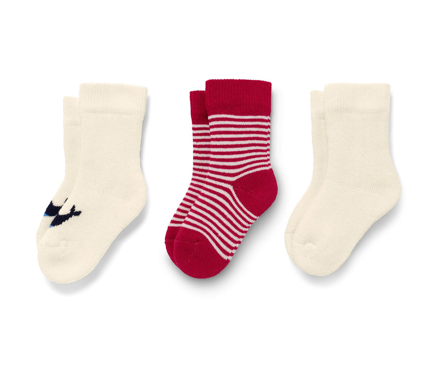 Trois paires de chaussettes pour bébé : couleur crème avec des baleines bleues et rayées rouge et blanc.
