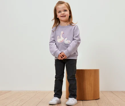 Une fille porte un sweat-shirt pour enfant avec intérieur gratté et motif cygne.