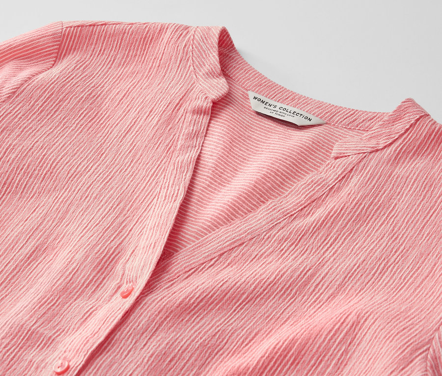 Gros plan sur une tunique longue rayée corail.