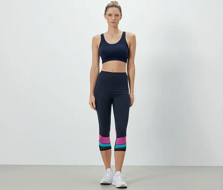 Une femme porte un soutien-gorge de sport et un corsaire de sport.