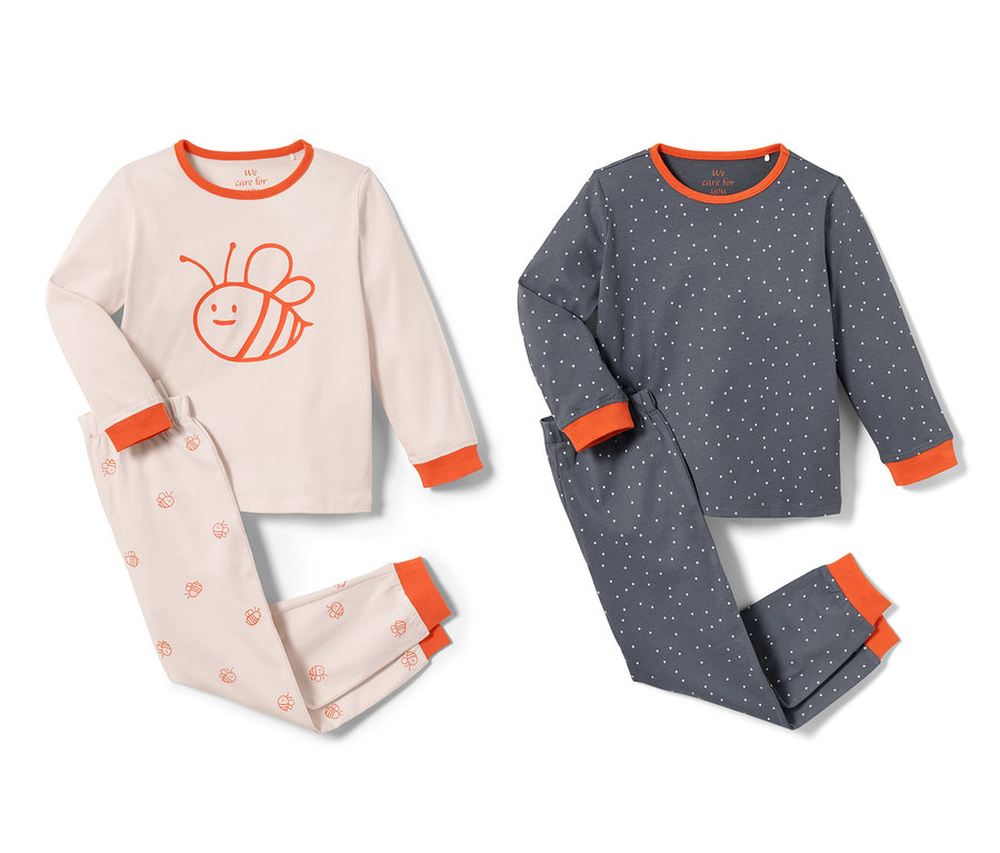 Deux pyjamas pour tout-petits, un rose avec un motif d'abeille, un bleu avec des pois.