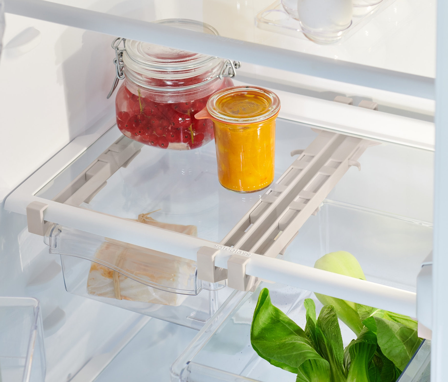 Vue intérieure d'un réfrigérateur avec des aliments et 2 compartiments de réfrigérateur extensibles.