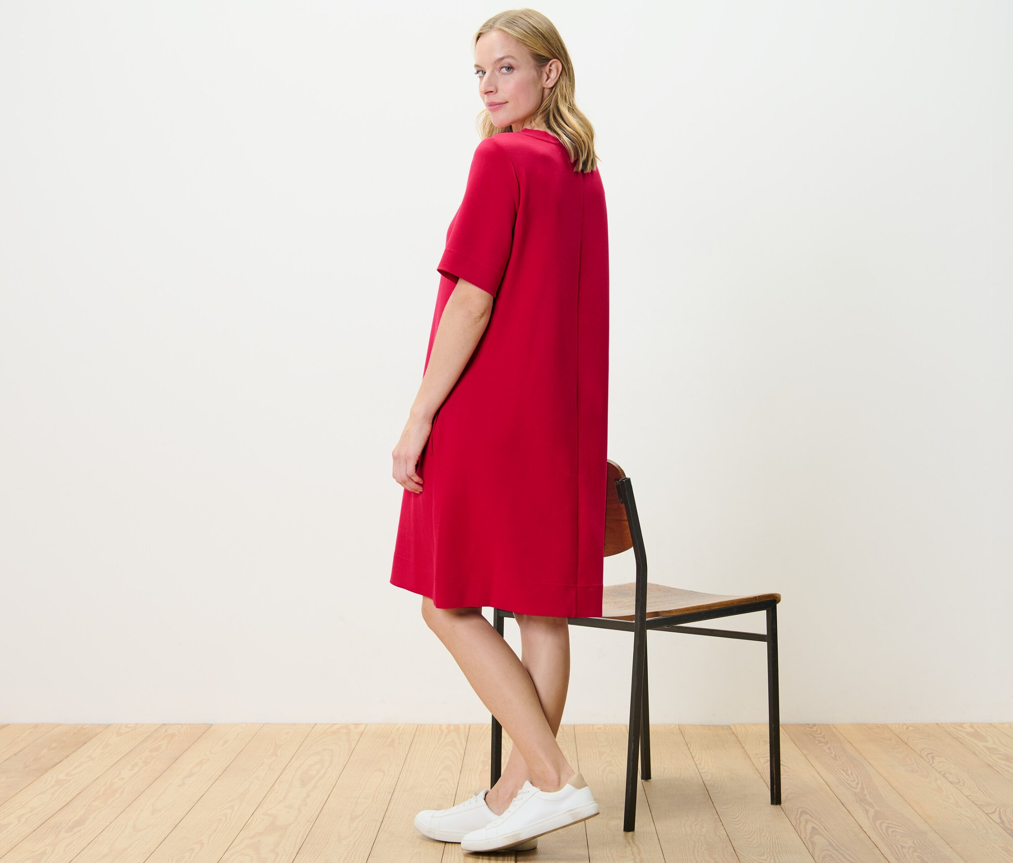 Femme posant en robe de survêtement rouge.