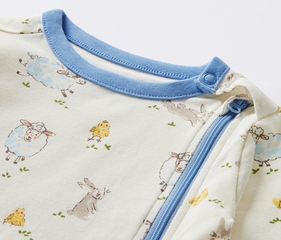 Détail d'un pyjama pour bébé avec des motifs d'animaux.