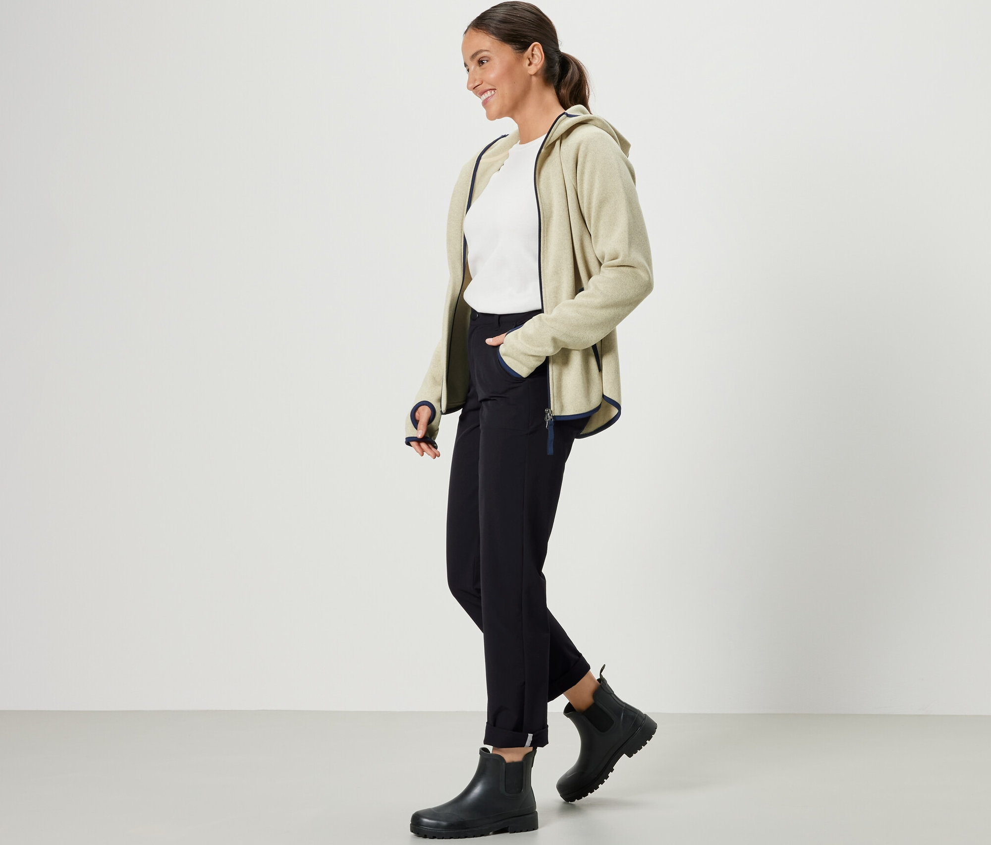 Femme portant un gilet en polaire beige zippé et un pantalon softshell noir.