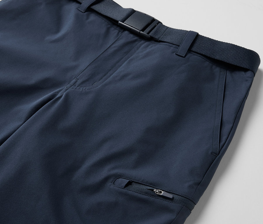 Gros plan sur un pantalon technique 2 en 1 bleu avec une ceinture.