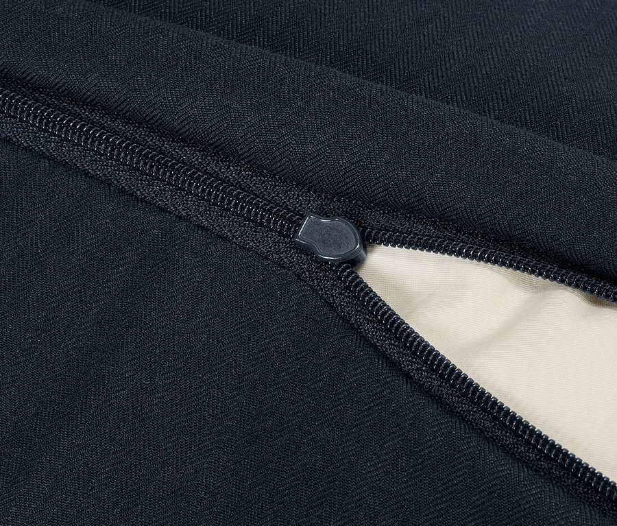 Gros plan d'un produit textile bleu avec une fermeture éclair ouverte révélant un intérieur beige.