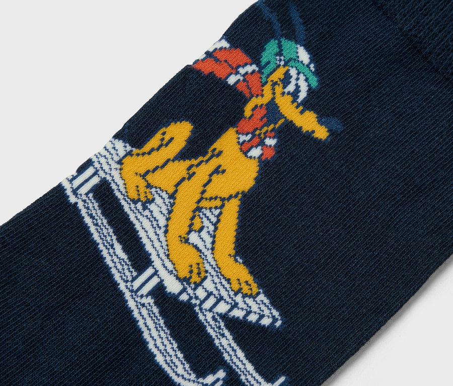Gros plan d'une chaussette bleu marine avec un personnage de dessin animé jaune faisant du ski.