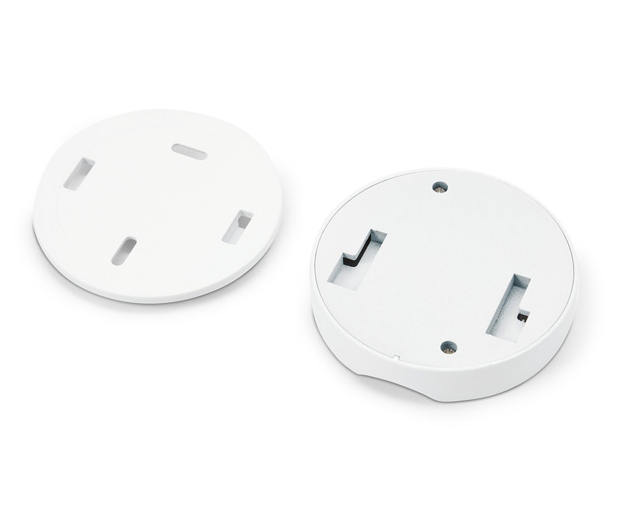 Deux plaques rondes blanches avec des ouvertures reposent sur un fond blanc.