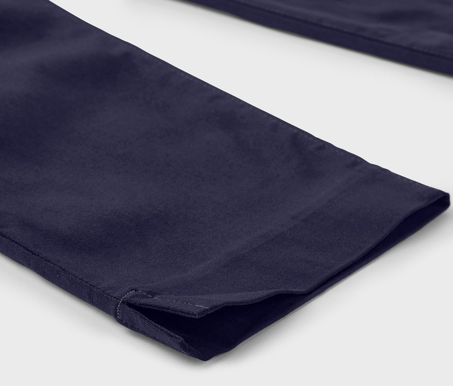 Détail d'un pantalon : Pantalon 3/4 en bengaline bleu foncé avec fente à l'ourlet.