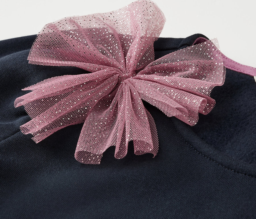Vêtement bleu marine avec un nœud rose.