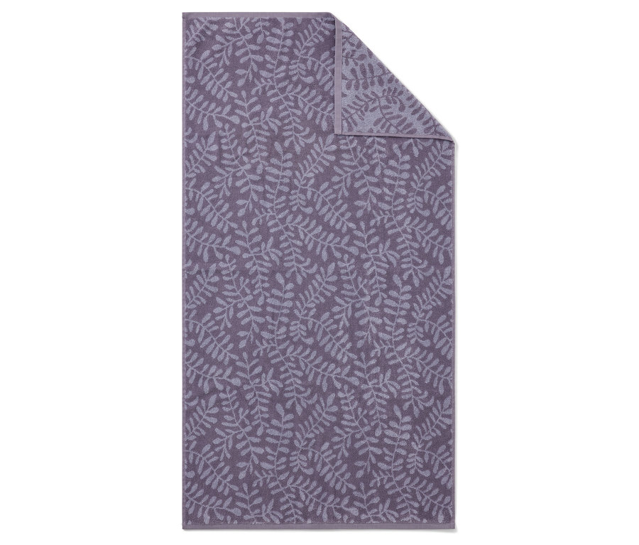 Une serviette violette avec un motif de feuilles, partiellement pliée.
