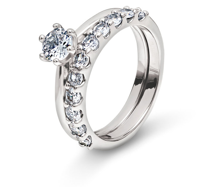 Deux anneaux argentés avec des pierres claires sur fond blanc.