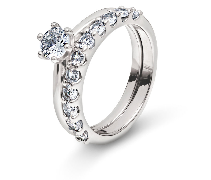 Deux anneaux argentés avec des pierres claires sur fond blanc.