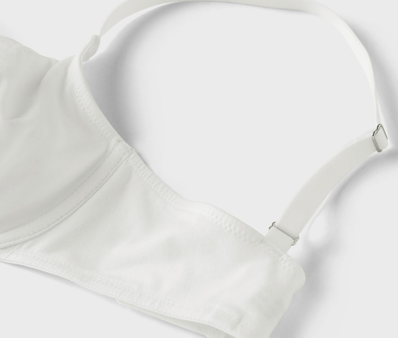 Détail d'un soutien-gorge blanc avec une bretelle réglable.
