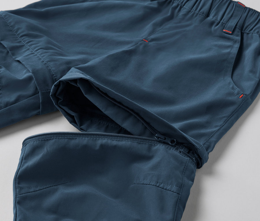 Gros plan d'un pantalon fonctionnel bleu pour tout-petits avec une fermeture éclair au genou.