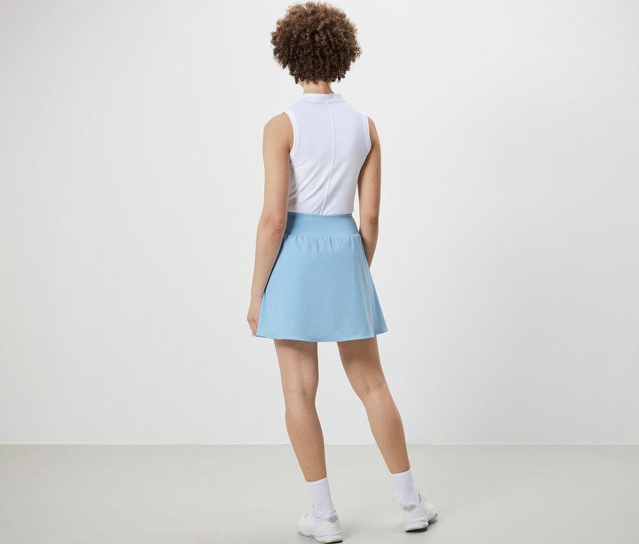 Femme vue de dos portant une jupe de sport bleu clair.