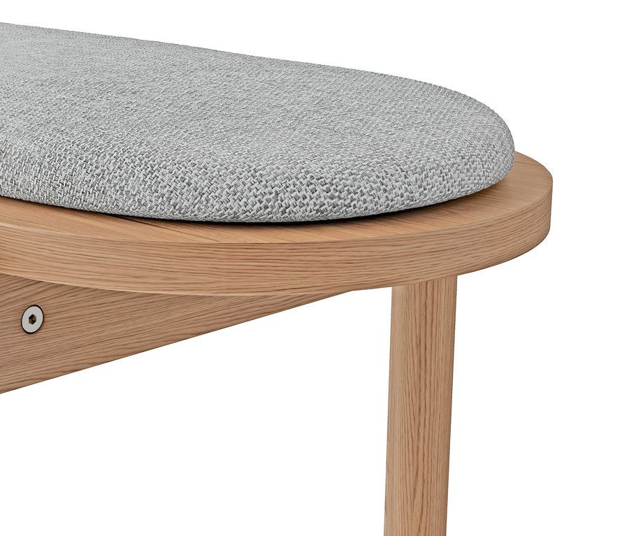 Gros plan d'un banc ovale avec coussin gris et pieds en bois.