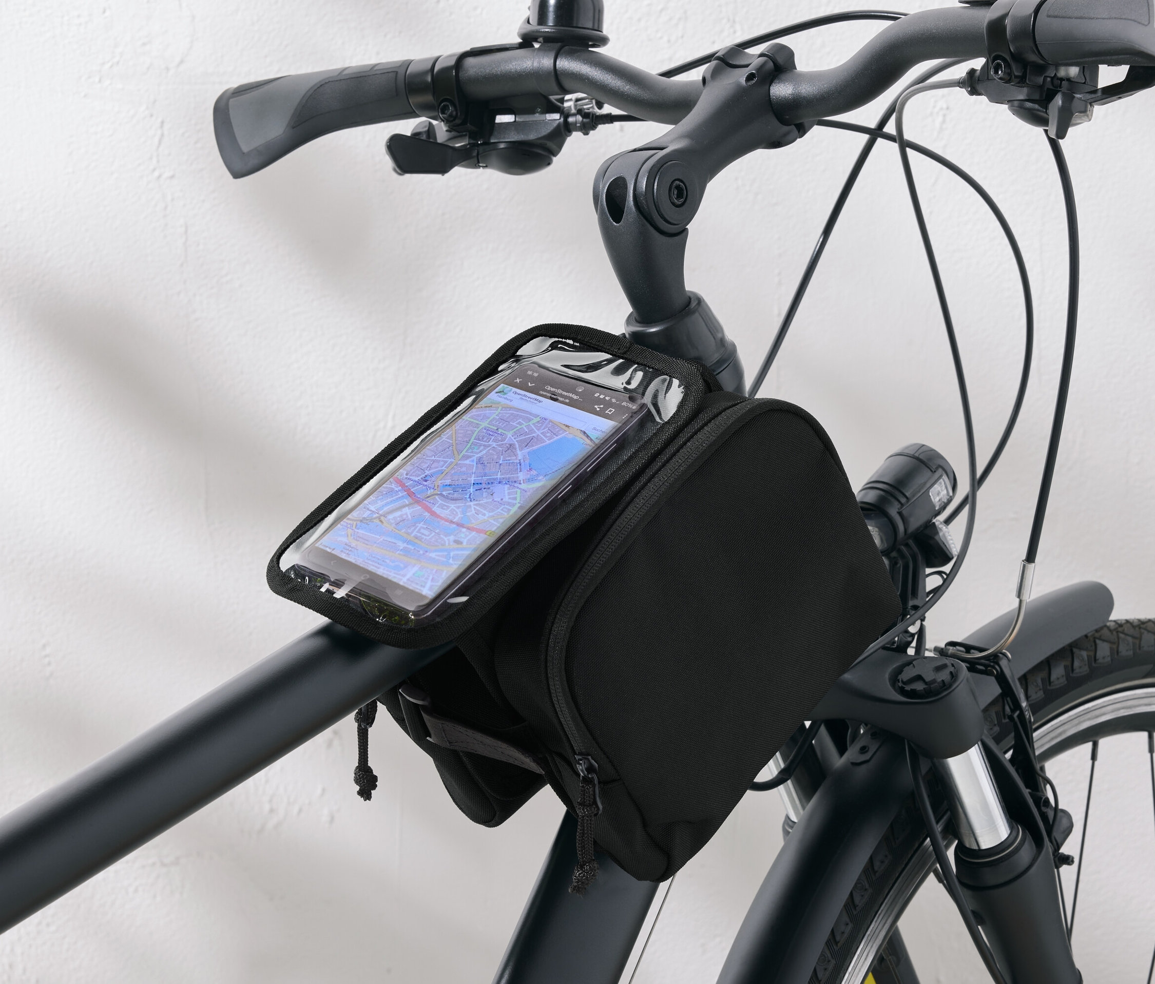 Sacoche de vélo noire avec un étui de téléphone transparent fixé au guidon d'un vélo.