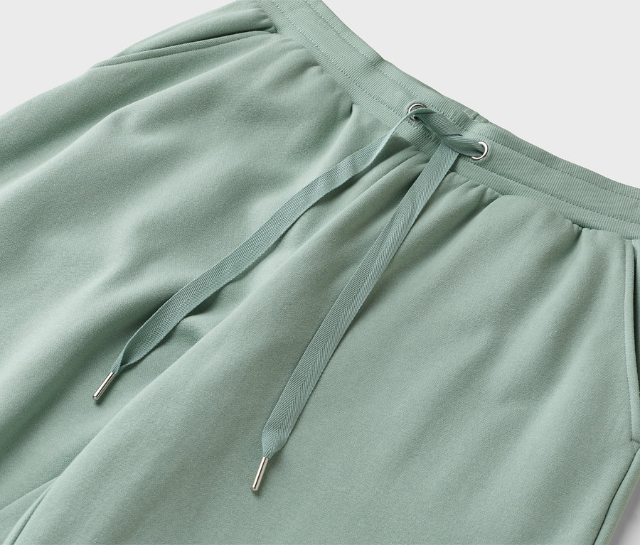 Gros plan d'un pantalon de survêtement vert clair avec cordon de serrage.
