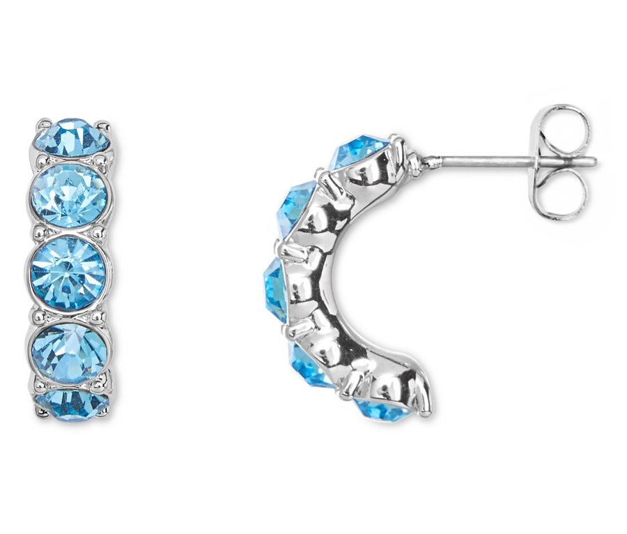 Gros plan d'une paire de boucles d'oreilles argentées avec chacune cinq pierres bleu clair.