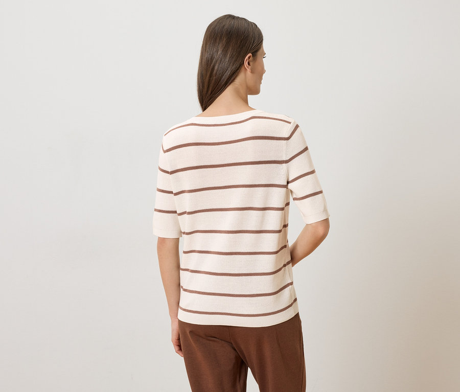 Vue arrière d'une femme portant un pantalon marron et un haut crème à rayures marron à manches courtes.