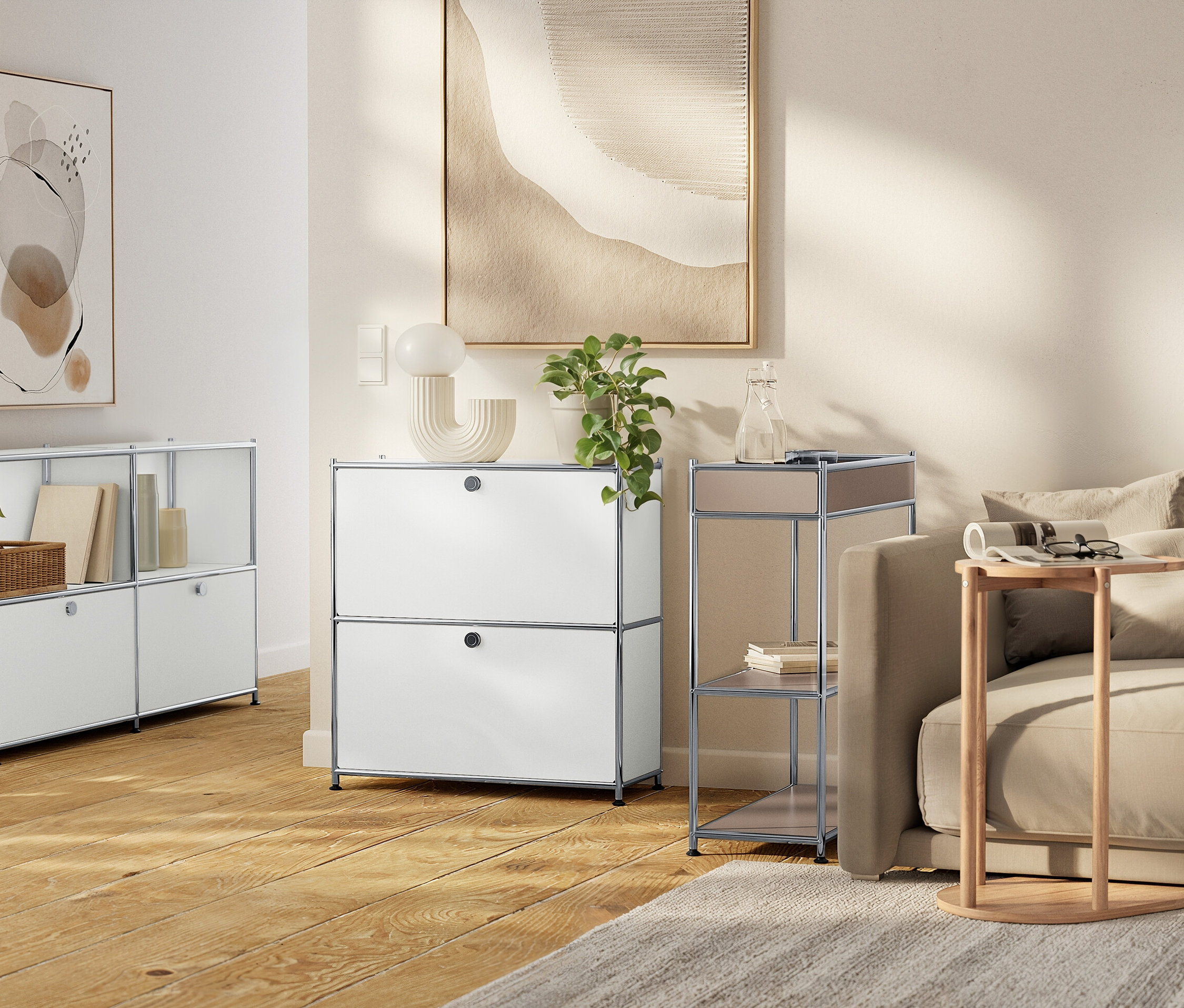 Un salon avec des meubles de rangement modulaires blancs, un canapé beige et des œuvres d'art neutres.