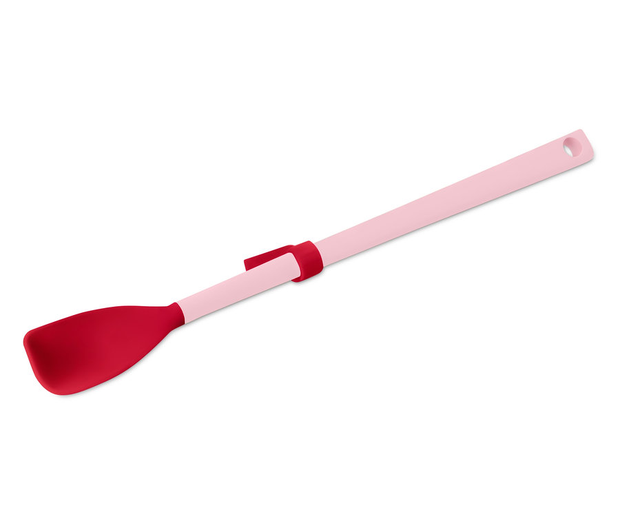 Une spatule rose avec une tête rouge et un trou de suspension est disposée en diagonale sur un fond blanc.