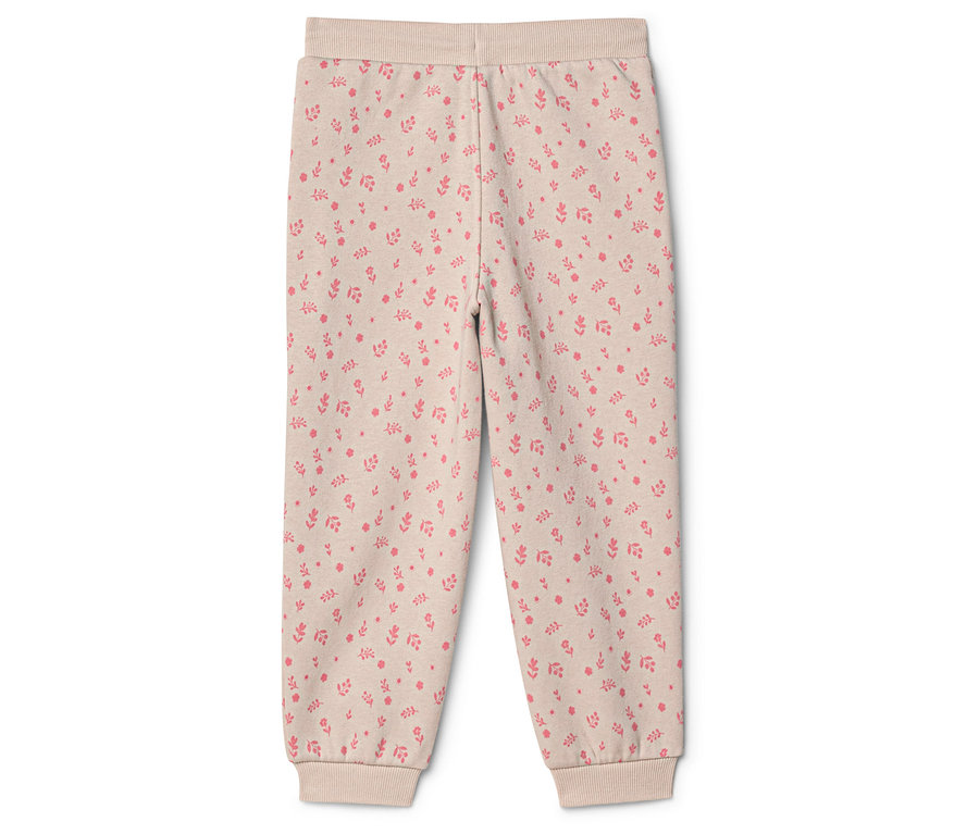 Pantalon beige à motif floral rose, avec des bords-côtes à la taille et aux chevilles.