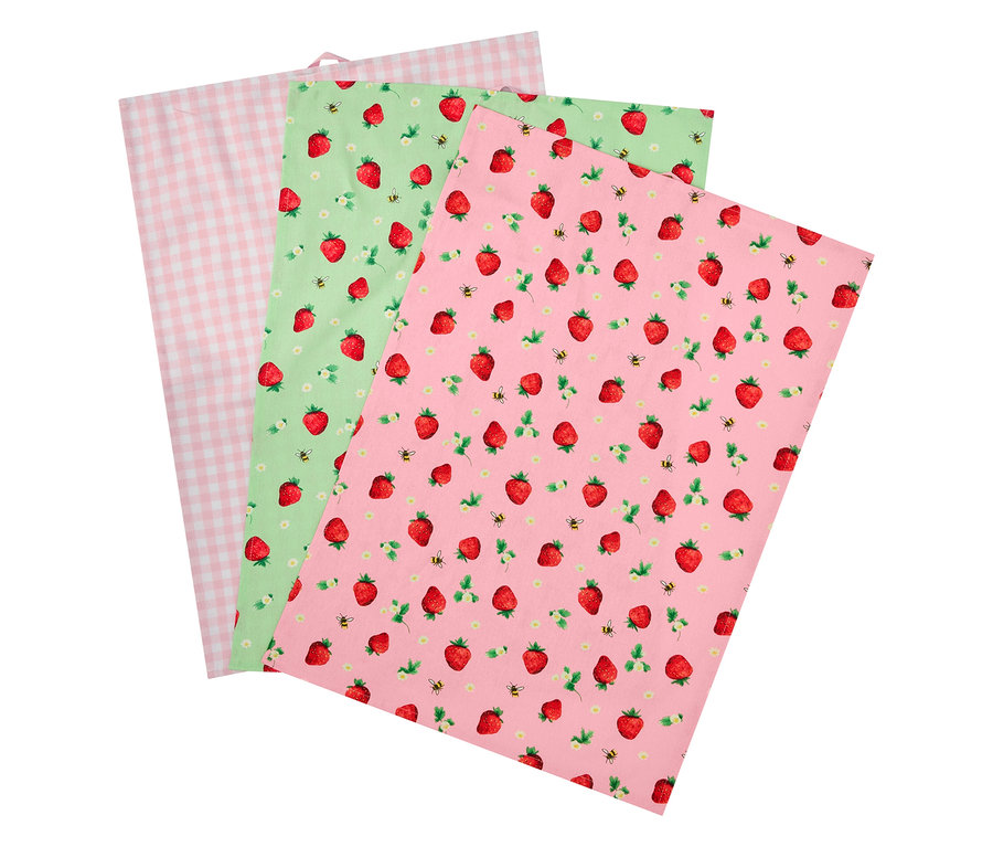 Trois serviettes en tissu, une rose à carreaux, une verte avec des fraises et des abeilles, et une rose avec des fraises et des abeilles.