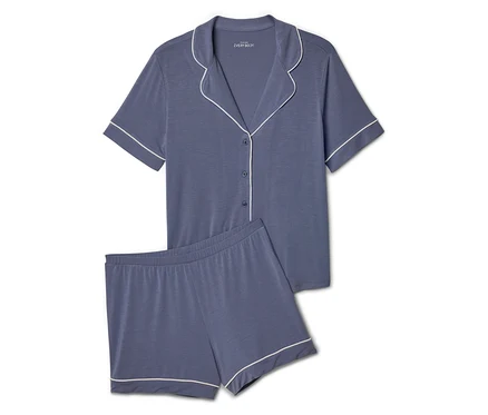 Ensemble de pyjama bleu avec bordure blanche comprenant un haut à manches courtes boutonné et un short.