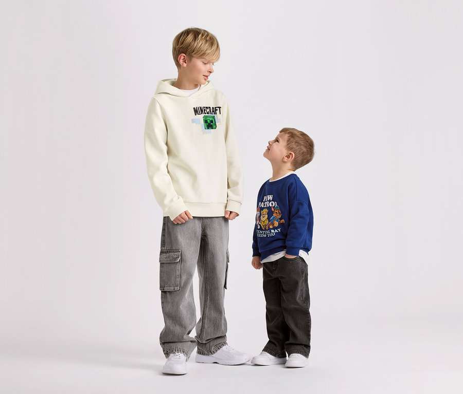 Deux garçons debout sur un fond blanc. Le plus grand porte un sweat-shirt MINECRAFT pour enfant avec intérieur gratté.