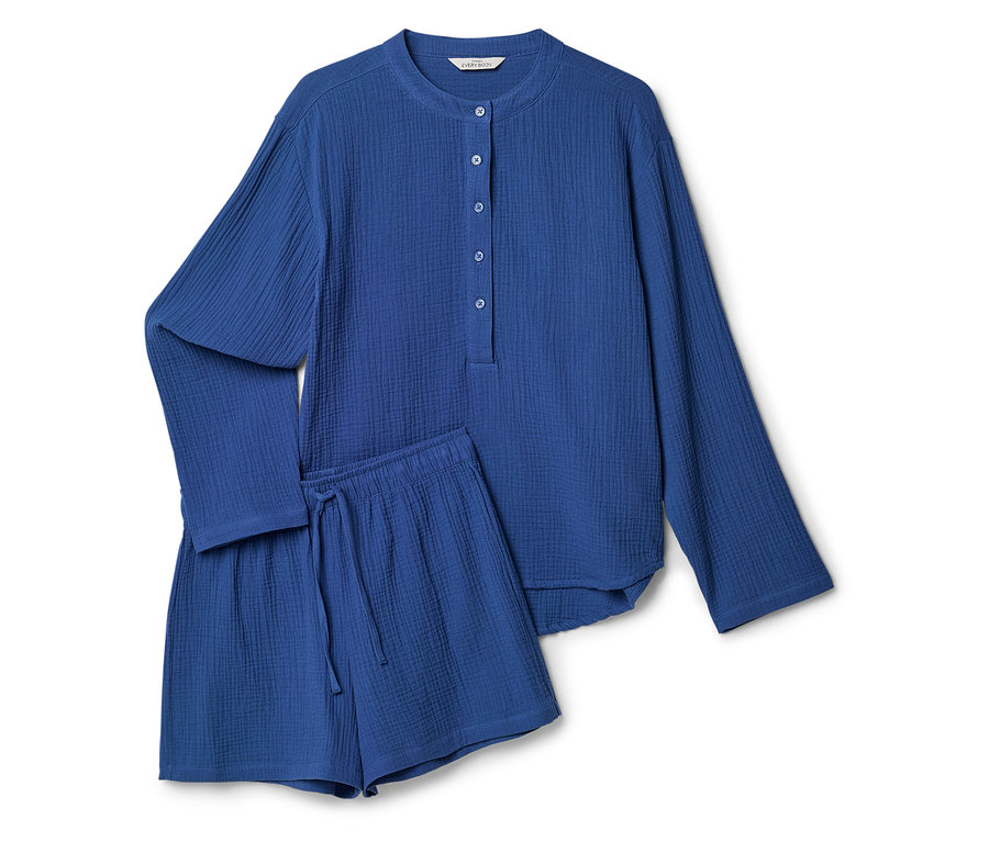 Un pyjama bleu composé d'un haut boutonné et d'un short posé sur un fond blanc.