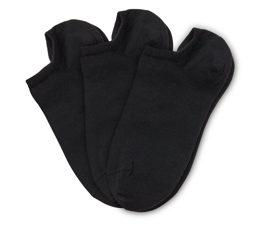 Trois chaussettes courtes noires sont posées les unes sur les autres sur un fond blanc.