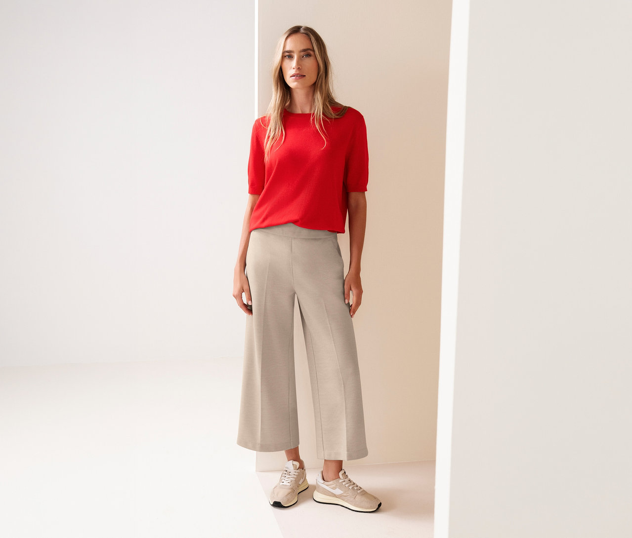 Femme portant un haut rouge et une culotte 7/8 Street One beige avec des baskets assorties.