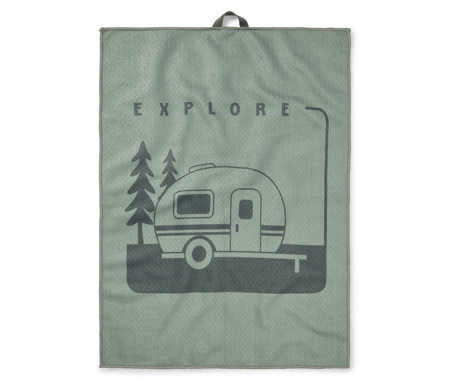 Une serviette vert clair avec une impression vert foncé d'une caravane entre deux arbres et le mot EXPLORE au-dessus.