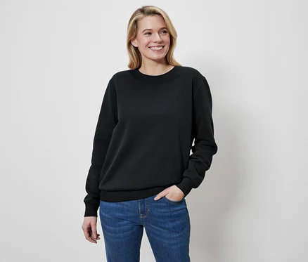 Femme blonde portant un pull noir et un jean.