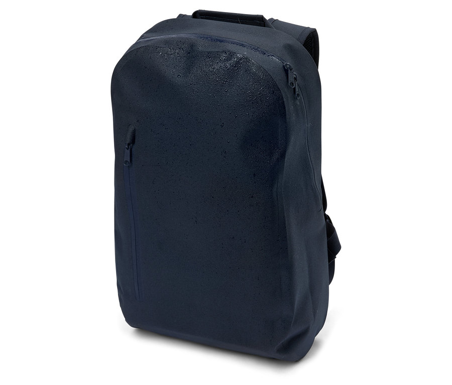 Sac à dos bleu marine avec fermetures éclair et gouttes d'eau, posé sur un fond blanc.