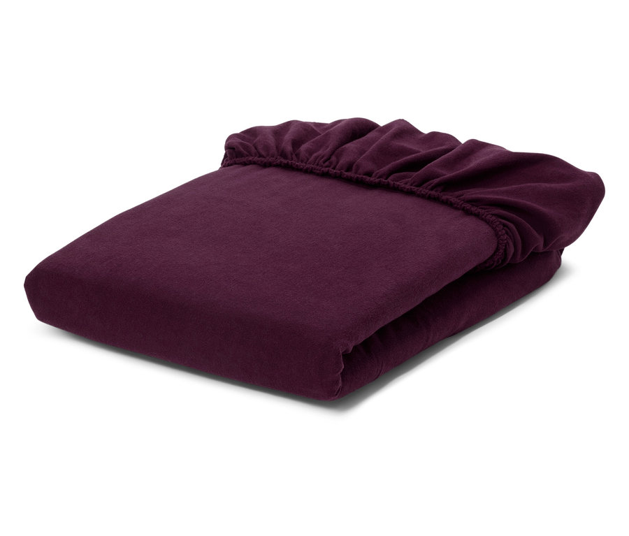 Drap-housse violet foncé plié avec élastique sur fond blanc.