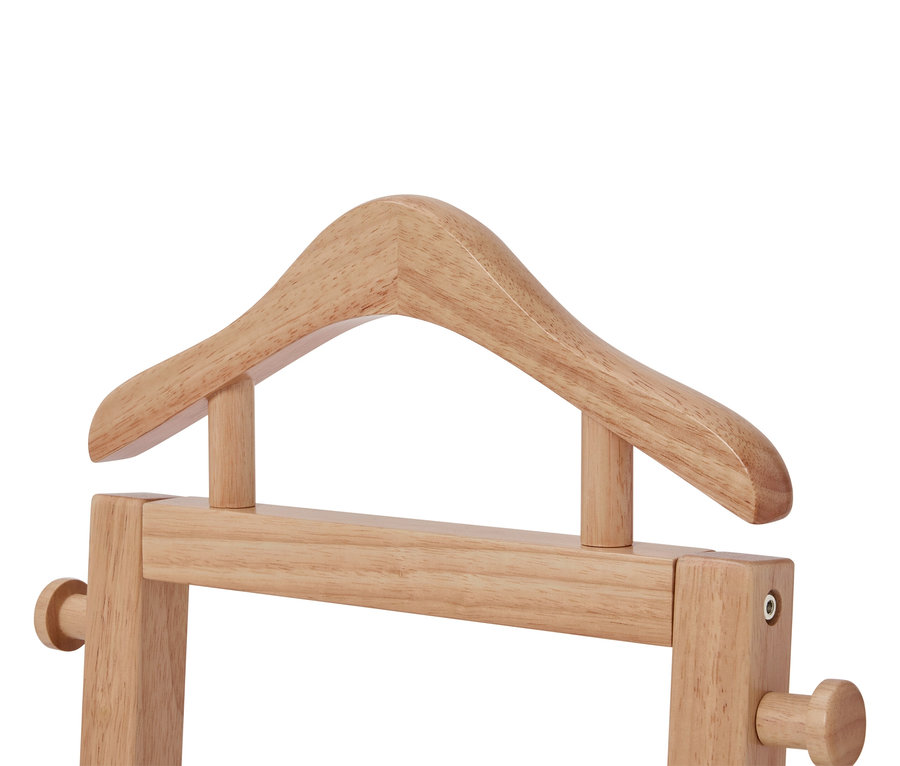 Gros plan sur un valet de chambre en bois marron clair avec un cintre.