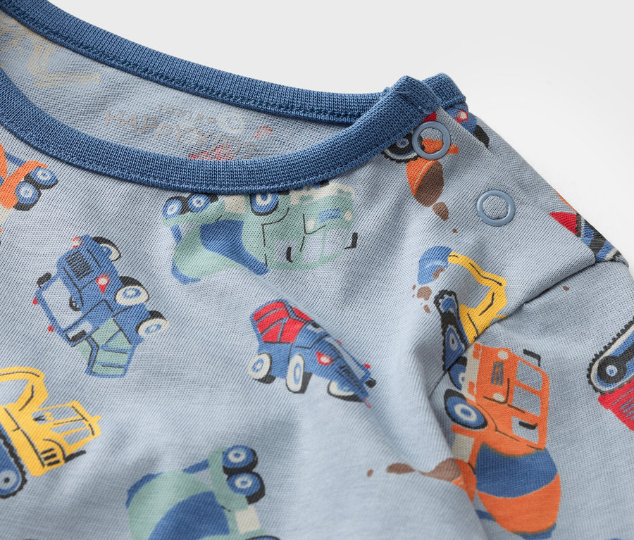 Gros plan sur un tissu bleu clair avec des véhicules multicolores.