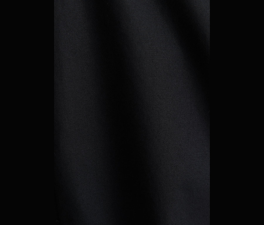 Gros plan sur un tissu popeline noir, probablement d'un chemisier, montrant sa texture et ses légers plis.