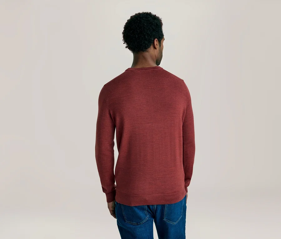 Homme de dos portant un pull rouge à manches longues et un jean bleu.