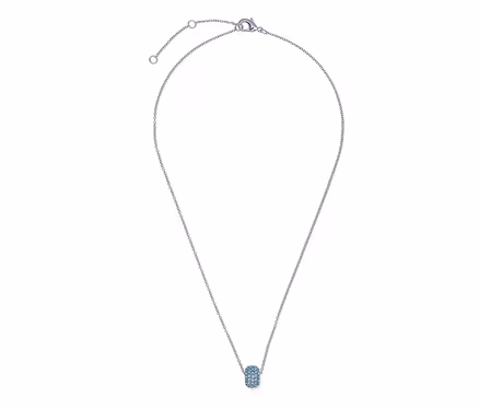 Gros plan d'un collier argenté avec un petit pendentif ovale aux accents bleus.