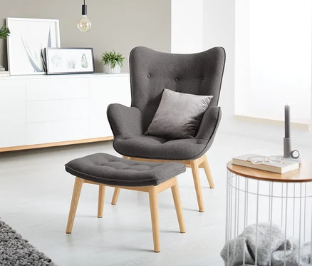 Fauteuil individuel gris foncé avec repose-pieds.