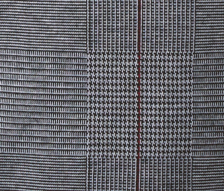 Gros plan sur le tissu à carreaux d'un sweat-shirt à manches 3/4.