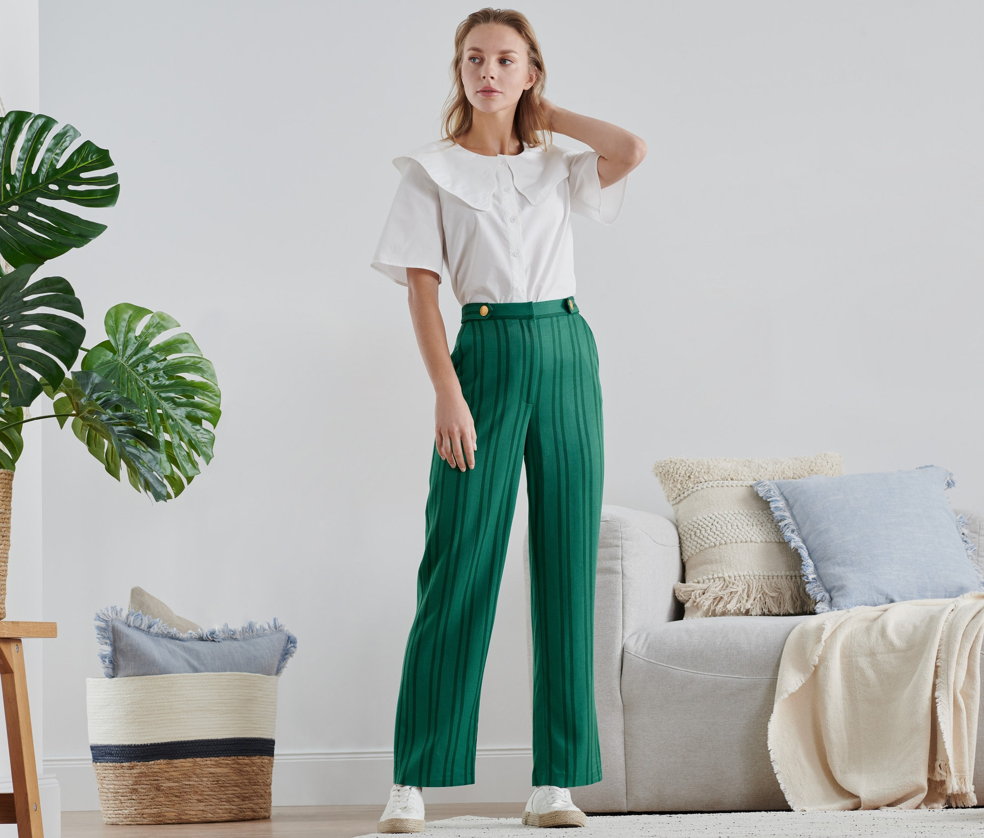 Femme posant dans un pantalon rayé vert.