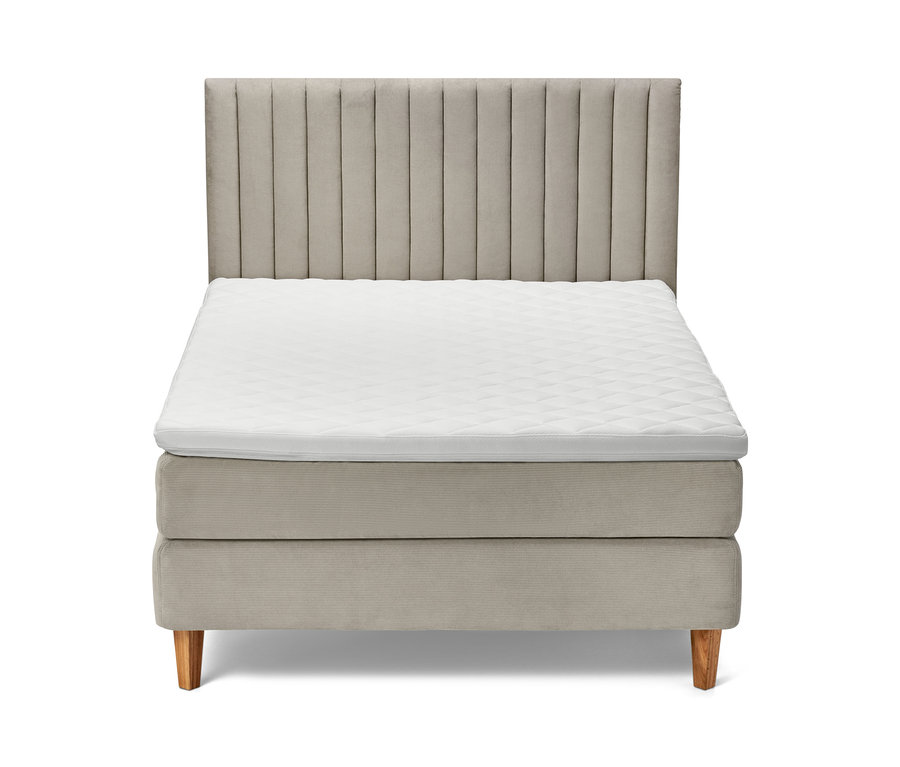 Lit à sommier tapissier beige avec tête de lit et matelas blanc.